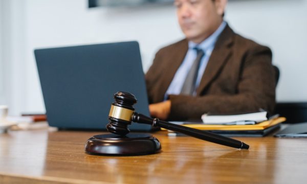 man using laptop and an image of a gavel