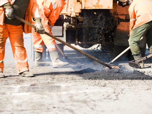 builders at Asphalting paver machine during Road street repairing works